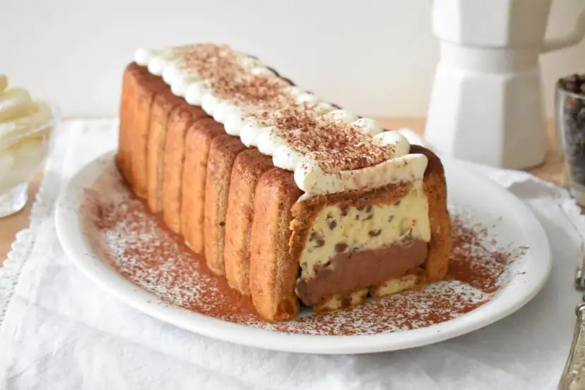 Pyszne włoskie ciasta: tiramisu w kształcie keksówki, otoczone biszkoptami, z kremem i kakao. Idealne na deser.