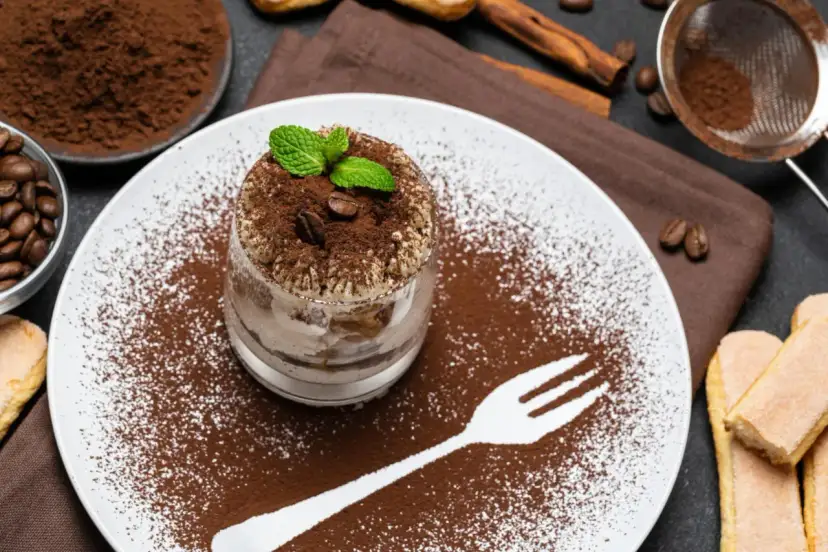 Pyszne tiramisu w pucharku, posypane kakao i kawą. Idealne desery co zamiast surowych jaj, z miętą i biszkoptami.