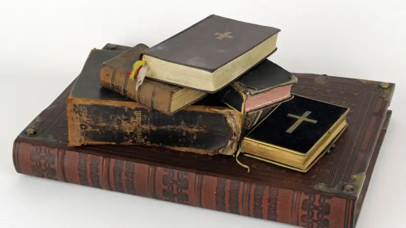 Stapel alter Bücher, einige mit Kreuzen auf dem Einband.