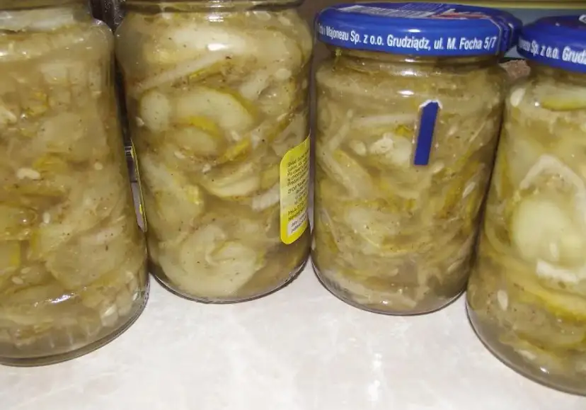 Słoiki z ogórkami i cebulą, gotowe do przygotowania sałatki szwedzkiej.