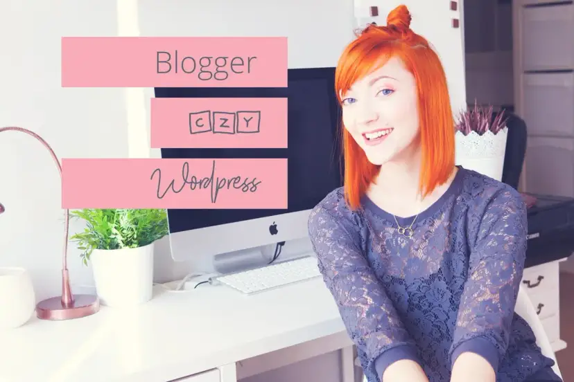 Uśmiechnięta rudowłosa kobieta siedzi przy biurku z komputerem, na którym widnieją napisy "Blogger" i "Wordpress".