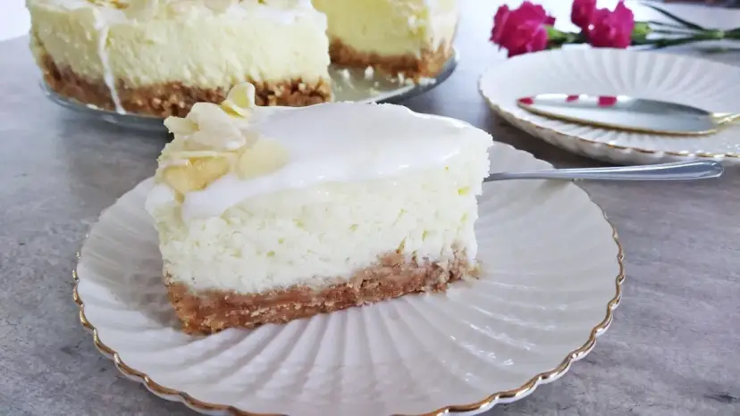 Pyszny sernik z mascarpone na kruchym spodzie, udekorowany płatkami migdałów. Idealny na deser.