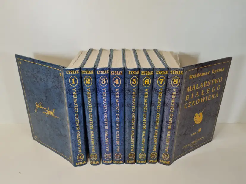 Osiem tomów książek Waldemara Łysiaka "Malarstwo białego człowieka" w niebieskich okładkach.