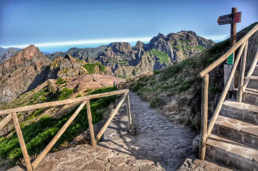 Kamienista ścieżka prowadzi przez górzysty krajobraz Madery, oferując widok na skaliste szczyty i ocean. To jedne z najpiękniejszych szlaków trekkingowych na Maderze, łączące lewady i szczyty.